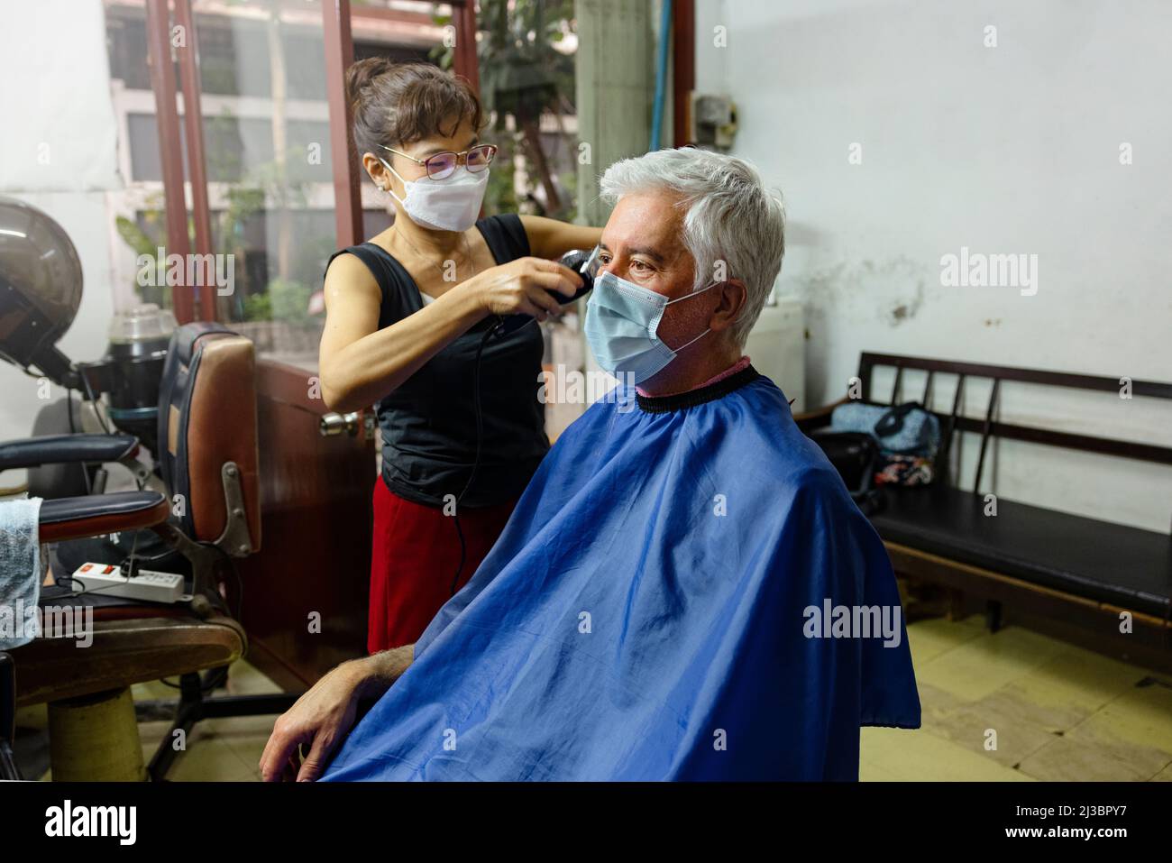 Älterer Mann, der im Friseursalon einen Haarschnitt bekommt Stockfoto