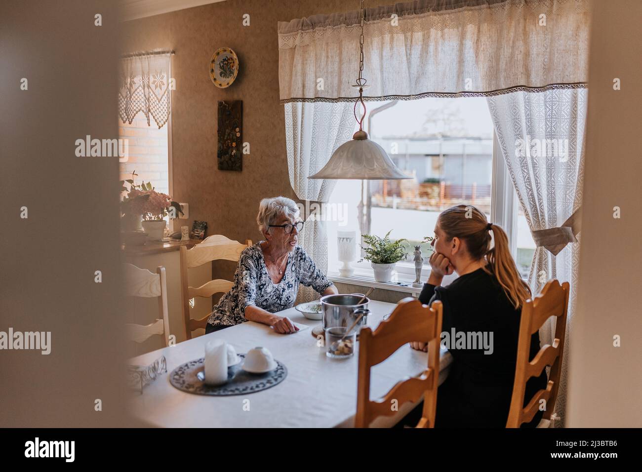 Großmutter und Erwachsene Enkelin essen zu Hause Stockfoto