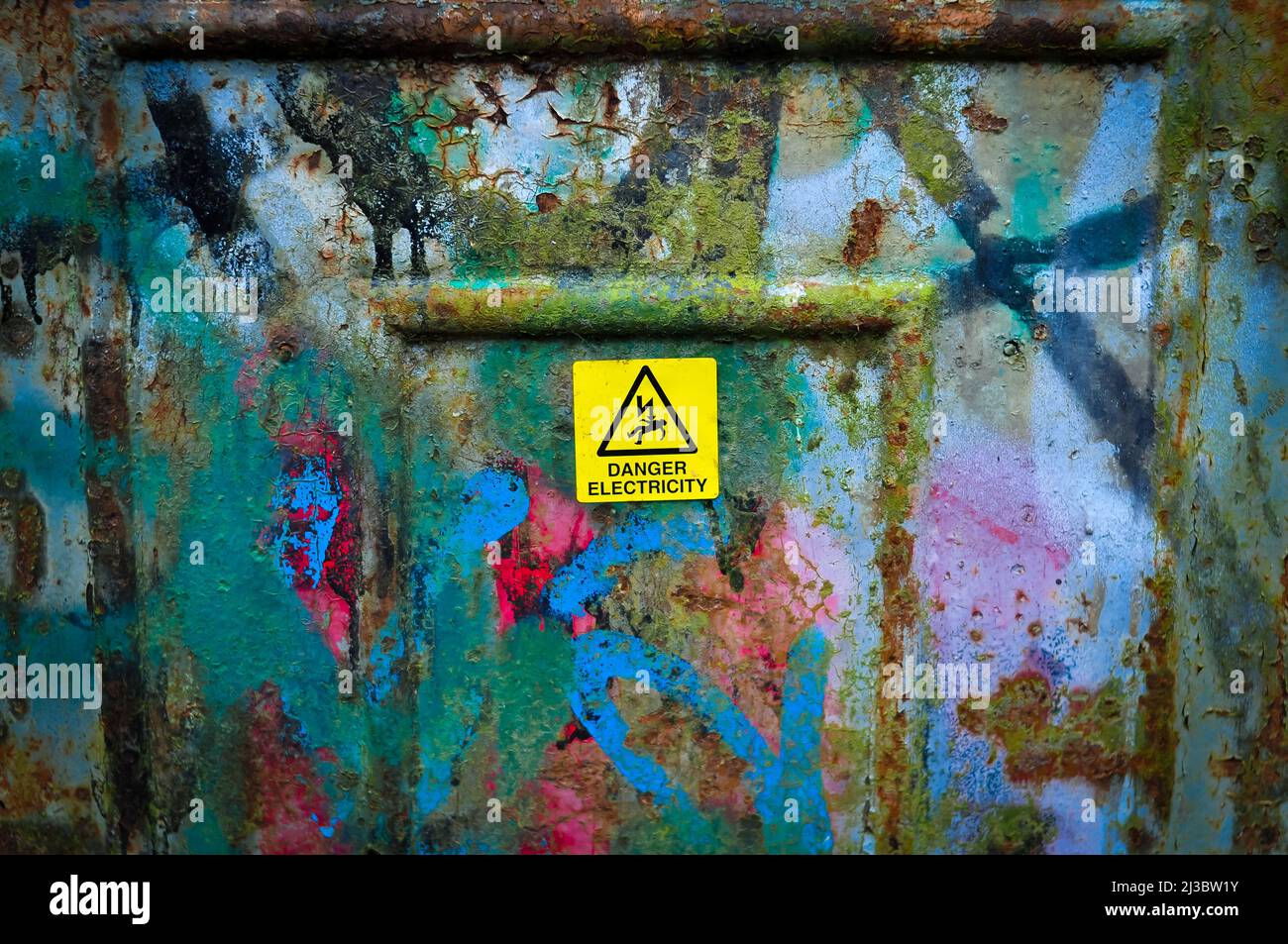 Gelbes Schild Gefahr Strom auf Metall kann außerhalb in England Stockfoto