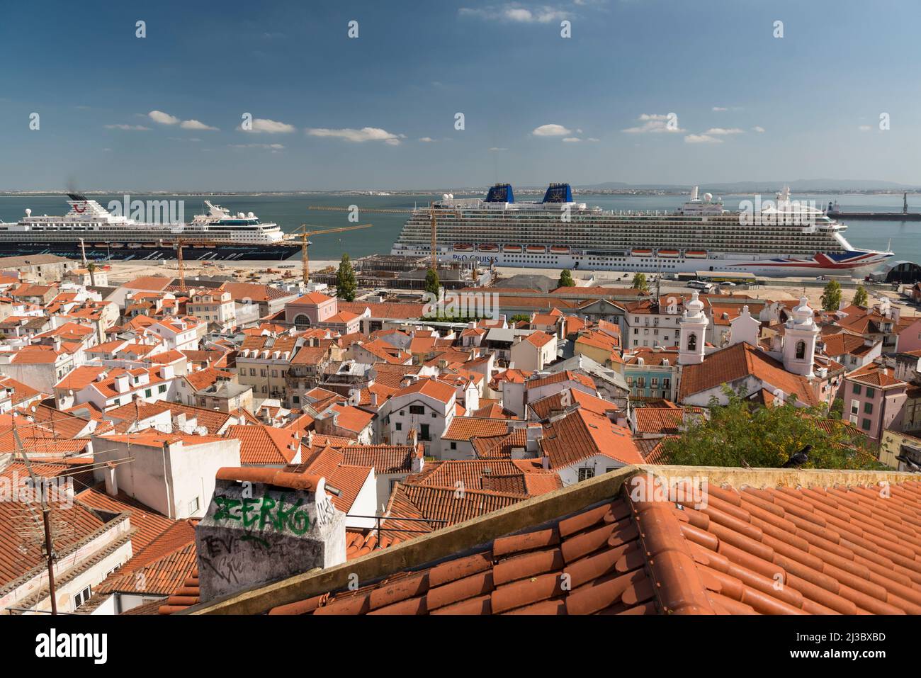 Blick vom Miradouro Santa Luzia auf die roten Dächer der Altstadt, die Kirche von São Miguel und festgedeckte hohe Kreuzschiffe. Lissabon, Portugal Stockfoto