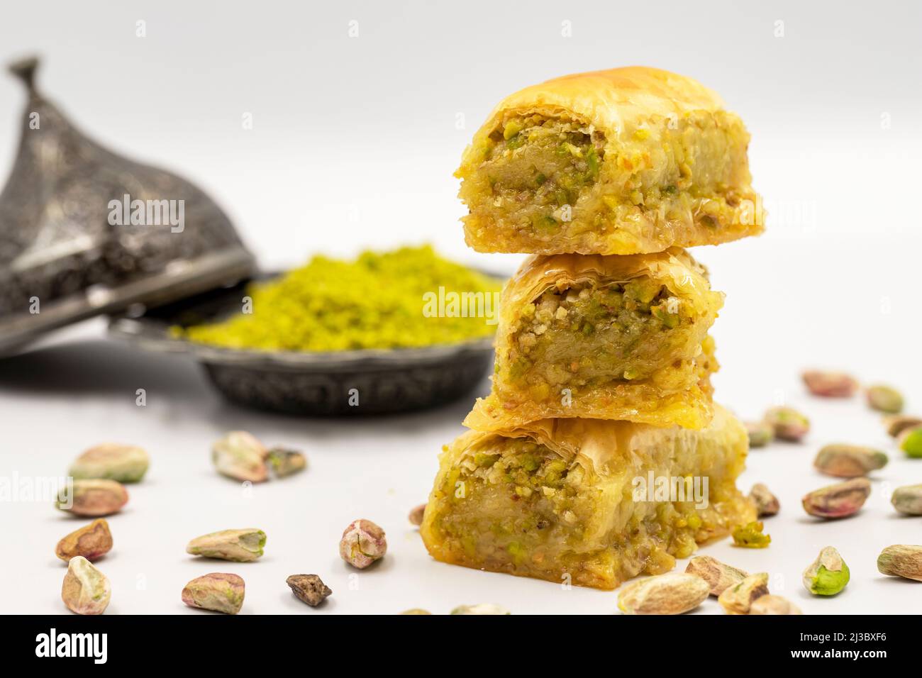 Baklava mit Pistazie auf weißem Hintergrund. Traditionelle mediterrane Küche, Delikatessen. Nahaufnahme Baklava Stockfoto