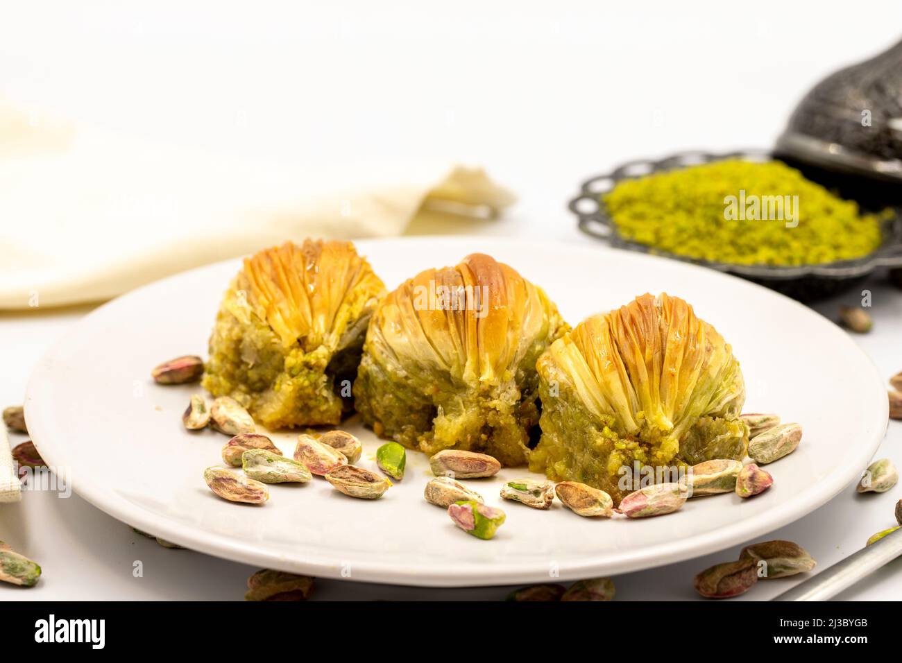 Muscheln Baklava auf weißem Hintergrund. Traditionelle mediterrane Spezialitäten. Nahaufnahme Pistazien Baklava. Lokaler Name midye Baklava Stockfoto