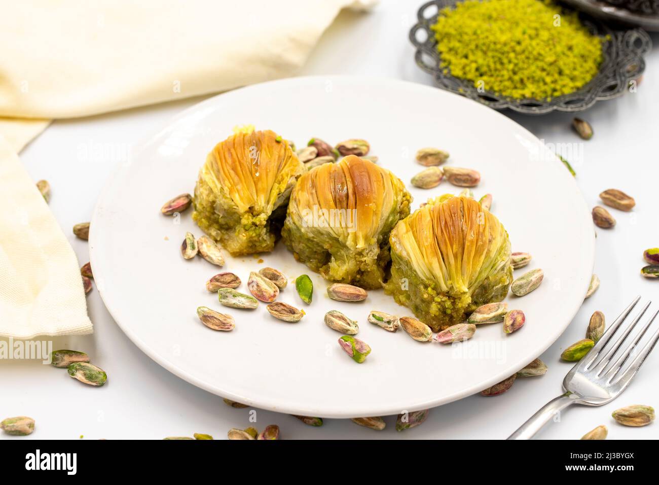 Muscheln Baklava auf weißem Hintergrund. Traditionelle mediterrane Spezialitäten. Nahaufnahme Pistazien Baklava. Lokaler Name midye Baklava Stockfoto