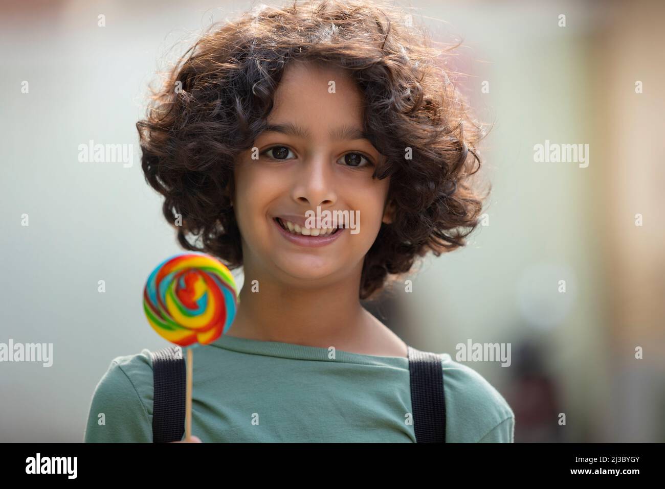 Porträt eines kleinen Jungen mit einem bunten großen Lutscher Stockfoto