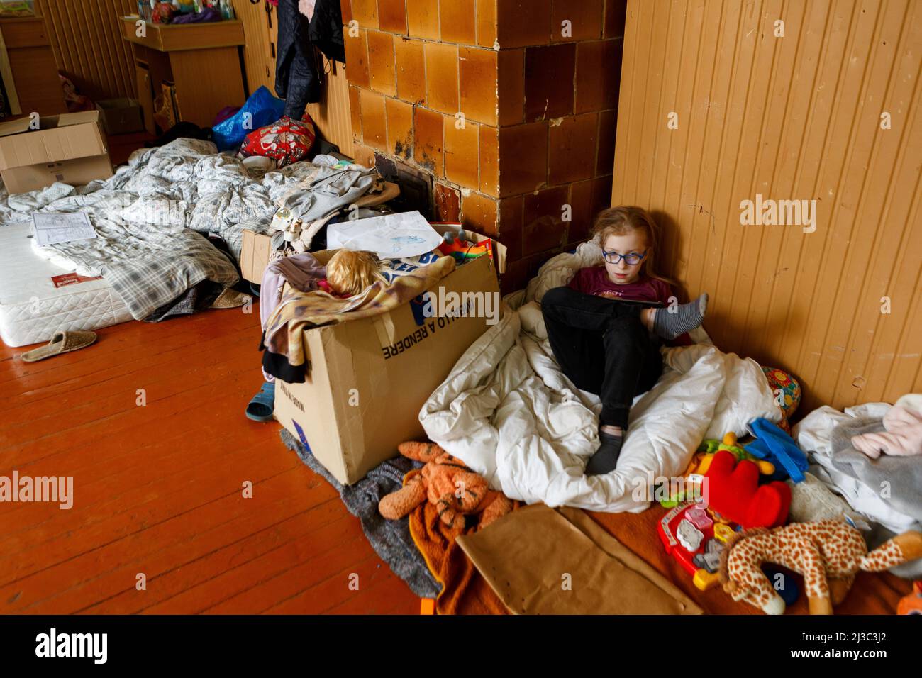 Nicht exklusiv: REGION ZAKARPATTIA, UKRAINE - 06. APRIL 2022 - eine 8-jährige Anastasiia spielt auf einem Tablet-PC in einem ehemaligen Schulzimmer. Eine Schule in Stockfoto