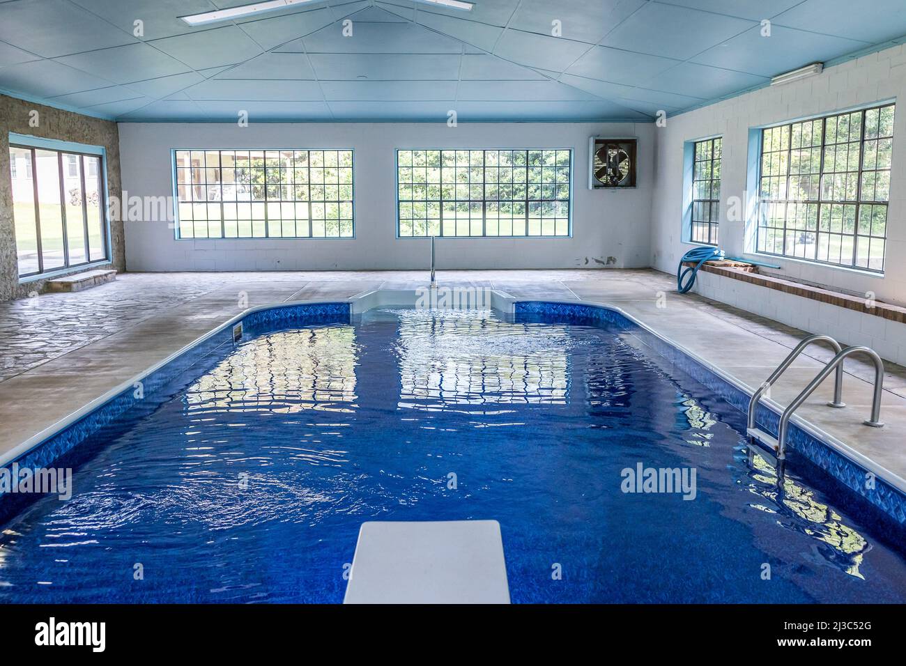 Großes Hallenbad mit viel natürlichem Licht durch die großen Fenster im Atrium Stockfoto