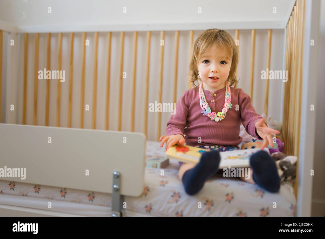 Das kleine Mädchen las zu Hause im Schlafzimmer ein Buch Stockfoto