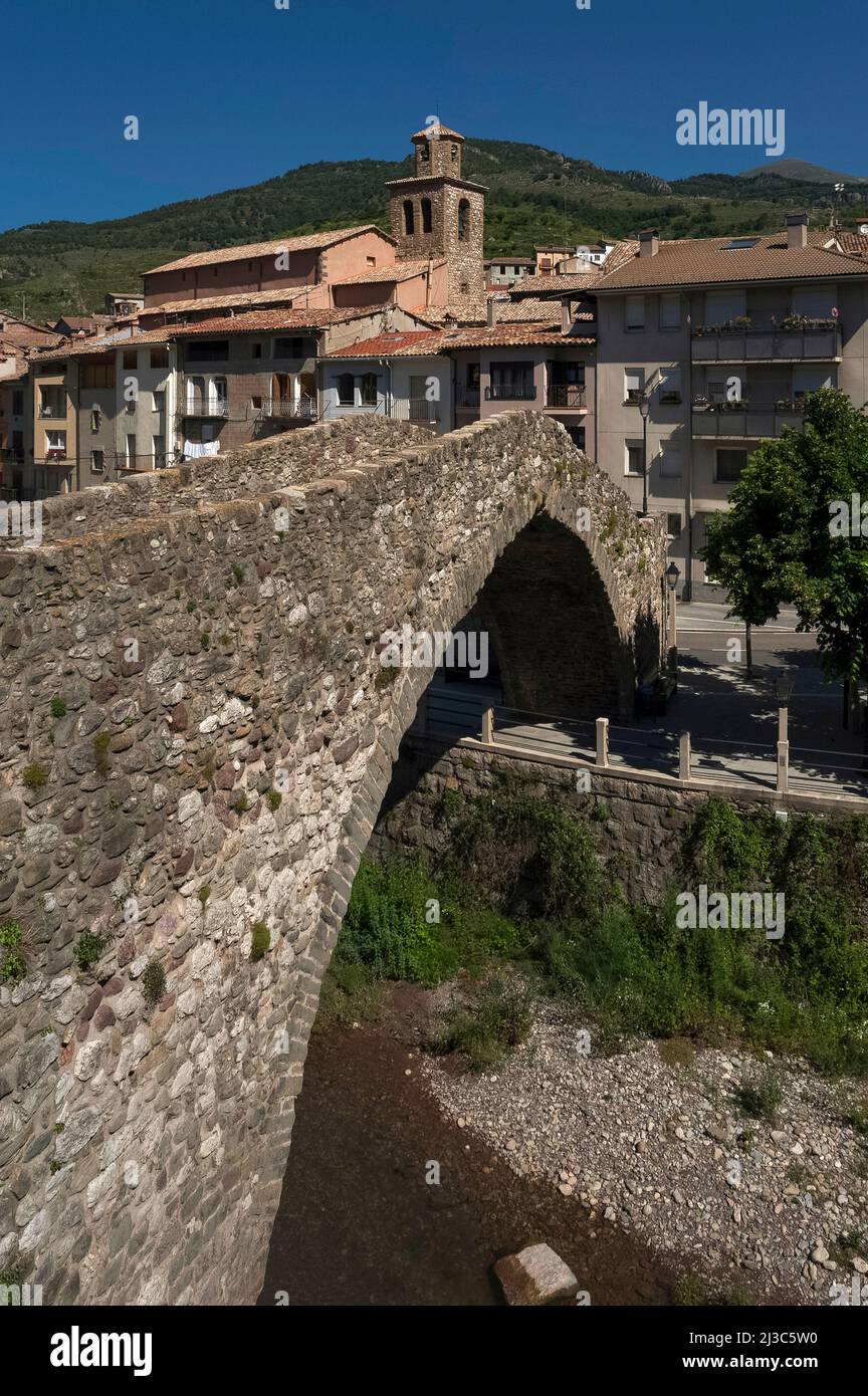 Die restaurierte Brücke Pont Vell aus dem Jahr 1300s erstreckt sich nun über den Fluss Llobregat in La Pobla de Lillet in Katalonien, Spanien, mit einem einzigen, anmutigen Eselrücken, aber sie hatte vielleicht einst zwei Bögen und die Aschenputtel-Fundamente der Säulen deuten darauf hin, dass sie römischen Ursprungs sein könnte. Stockfoto