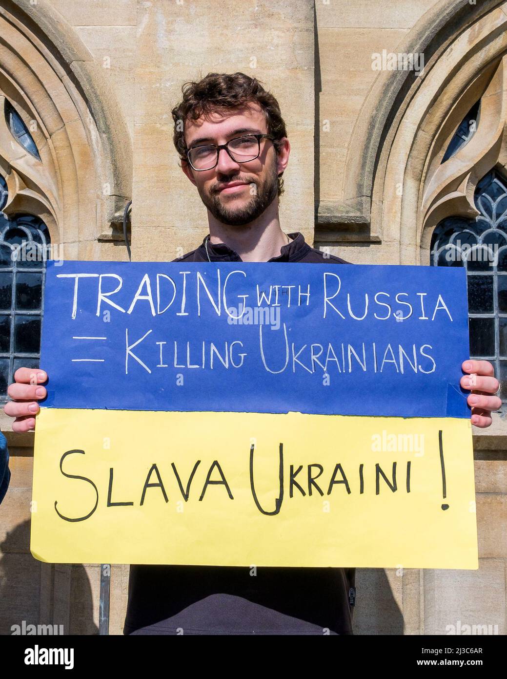 Ein Protestler vor der Abtei von Bath hält ein Plakat gegen den Krieg, während er an einer Demonstration gegen die russische Invasion in der Ukraine teilnimmt Stockfoto