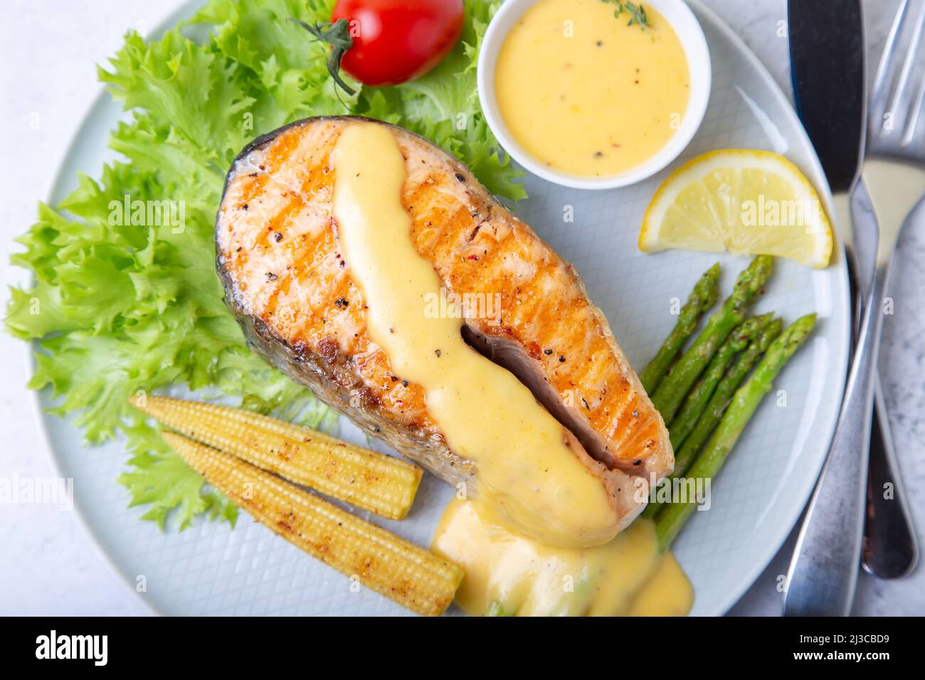 Gegrillter Lachs mit Spargel, Mais-Mini und Sauce Hollandaise. Nahaufnahme. Stockfoto