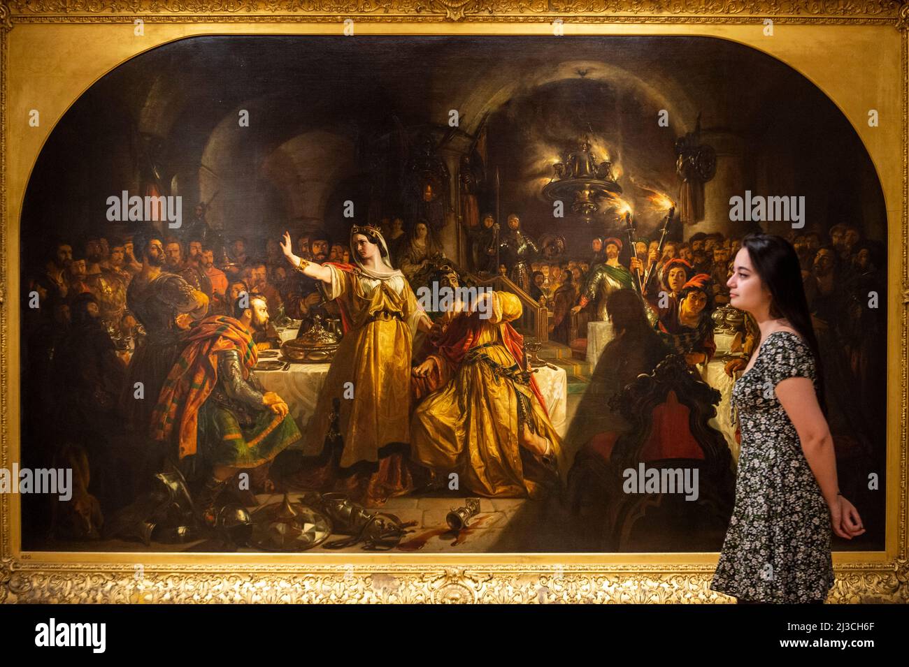 London, Großbritannien. 7. April 2022. Ein Mitarbeiter posiert mit „The Banquet Scene of Macbeth“, 1840, von Daniel Maclise. Vorschau auf „Inspired: Art inspired by Theatre, literature and music“, eine neue Ausstellung aus der permanenten Sammlung der Guildhall Art Gallery, die untersucht, wie bildende Künstler sich von Poesie, Theaterstücken, Romanen und Musik inspirieren ließen. Die Ausstellung markiert die Wiedereröffnung der Galerie, nachdem sie wegen Wartungsarbeiten geschlossen wurde. Werke aus dem 17.. Bis 19.. Jahrhundert sind vom 8. April bis zum 11. September 2022 zu sehen. Kredit: Stephen Chung / Alamy Live Nachrichten Stockfoto