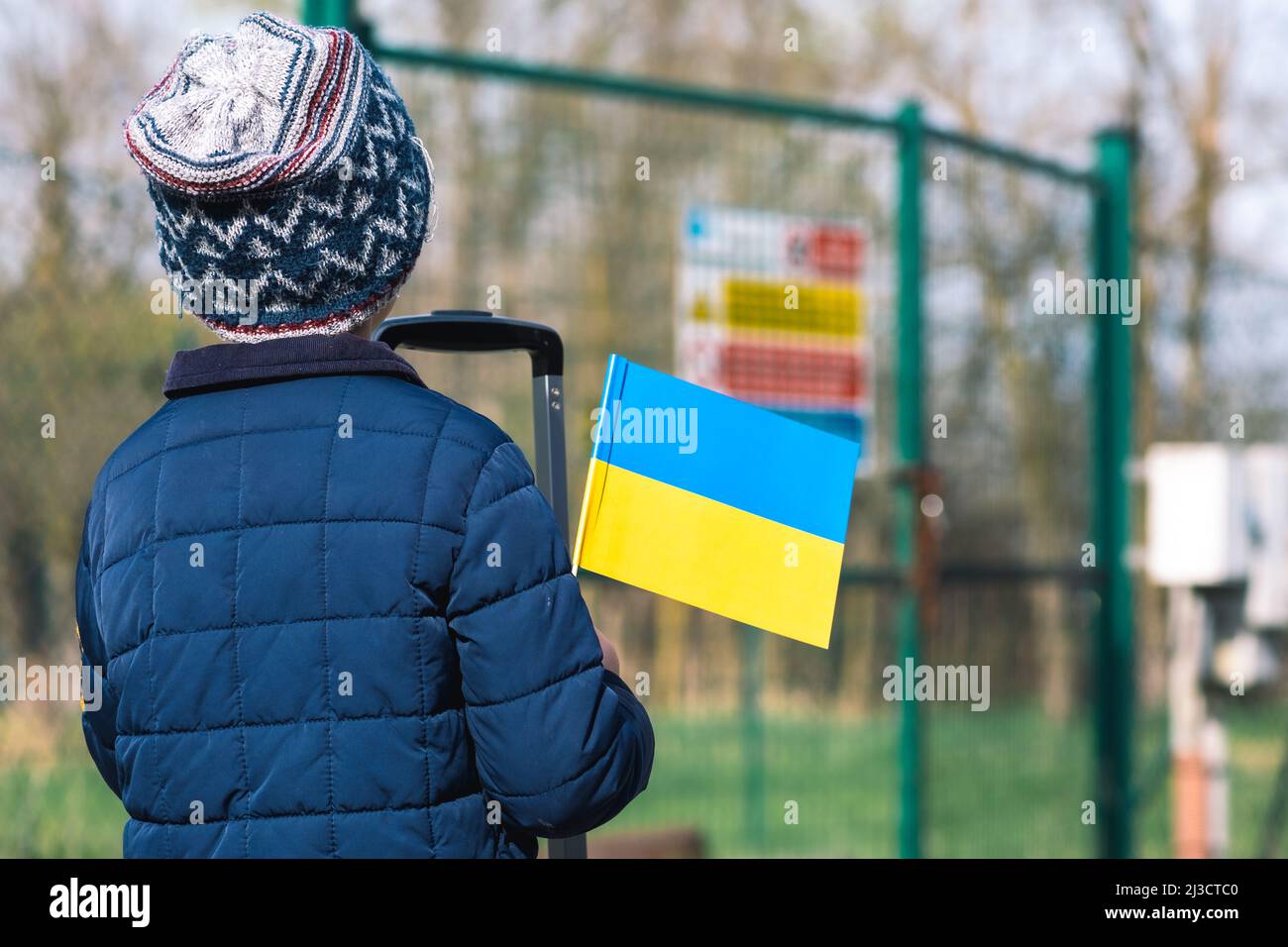 Kind oder Kind mit Winterkleidung, Hut und ukrainischer Flagge, das ...