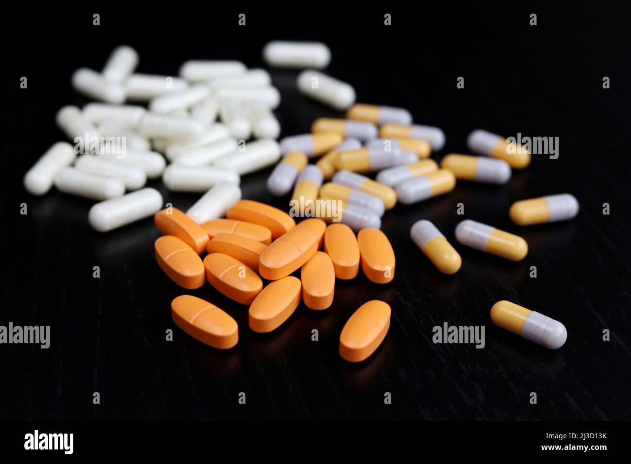 Verschiedene Pillen auf einem dunklen Holztisch, Medikamente in Kapseln. Konzept der Apotheke, Antibiotika, Vitamine Stockfoto