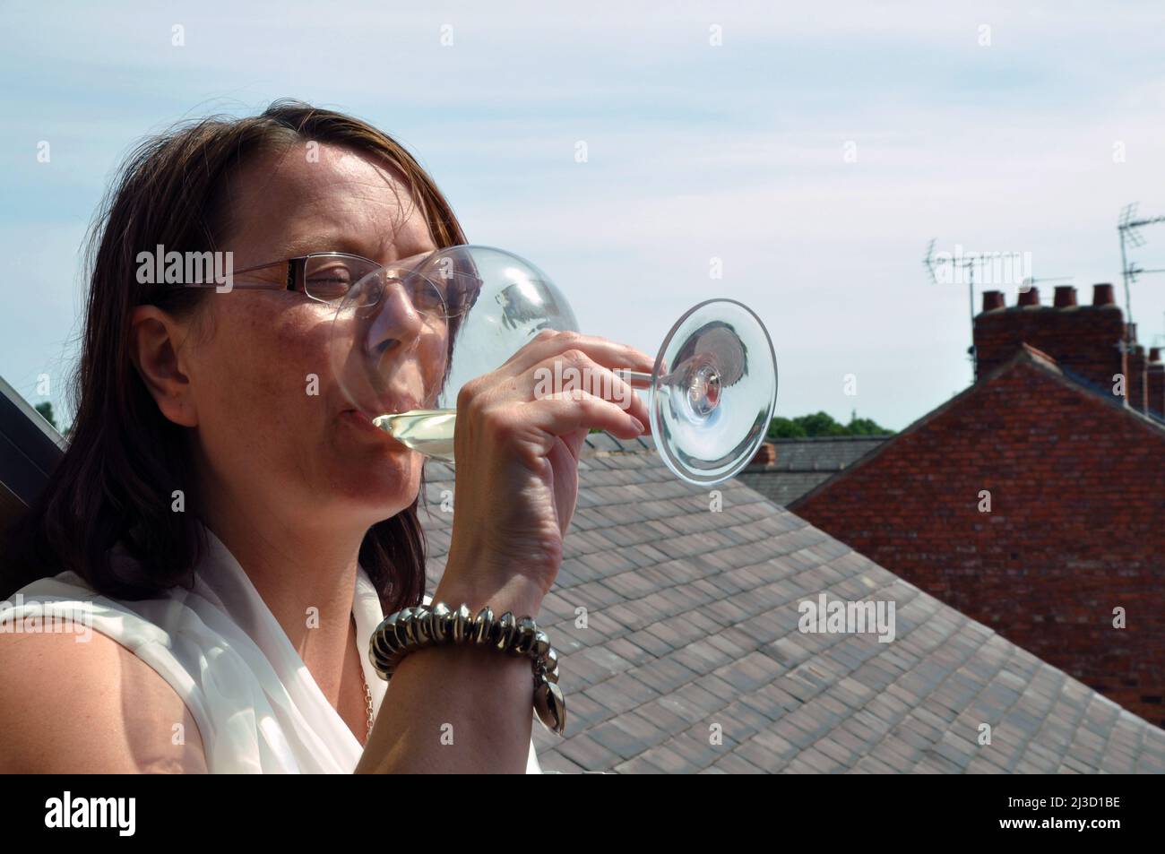 Frau, die in der Sonne trinkt Stockfoto