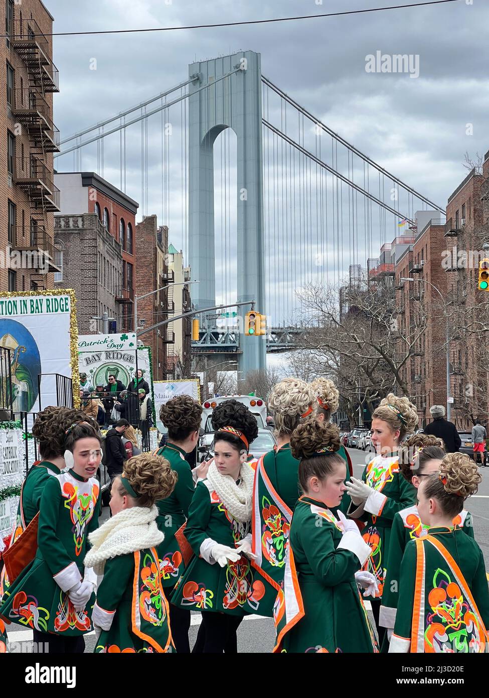 Teenager-Mädchen, Mitglieder einer irischen Tanzschule, die sich auf den marsch vorbereiten und bei der Saint Patrick's Day Parade in Bay Ridge, Brooklyn, auftreten. Verrazano Bridge im Hintergrund geht es zwischen Brooklyn und Staten Island in New York City. Stockfoto