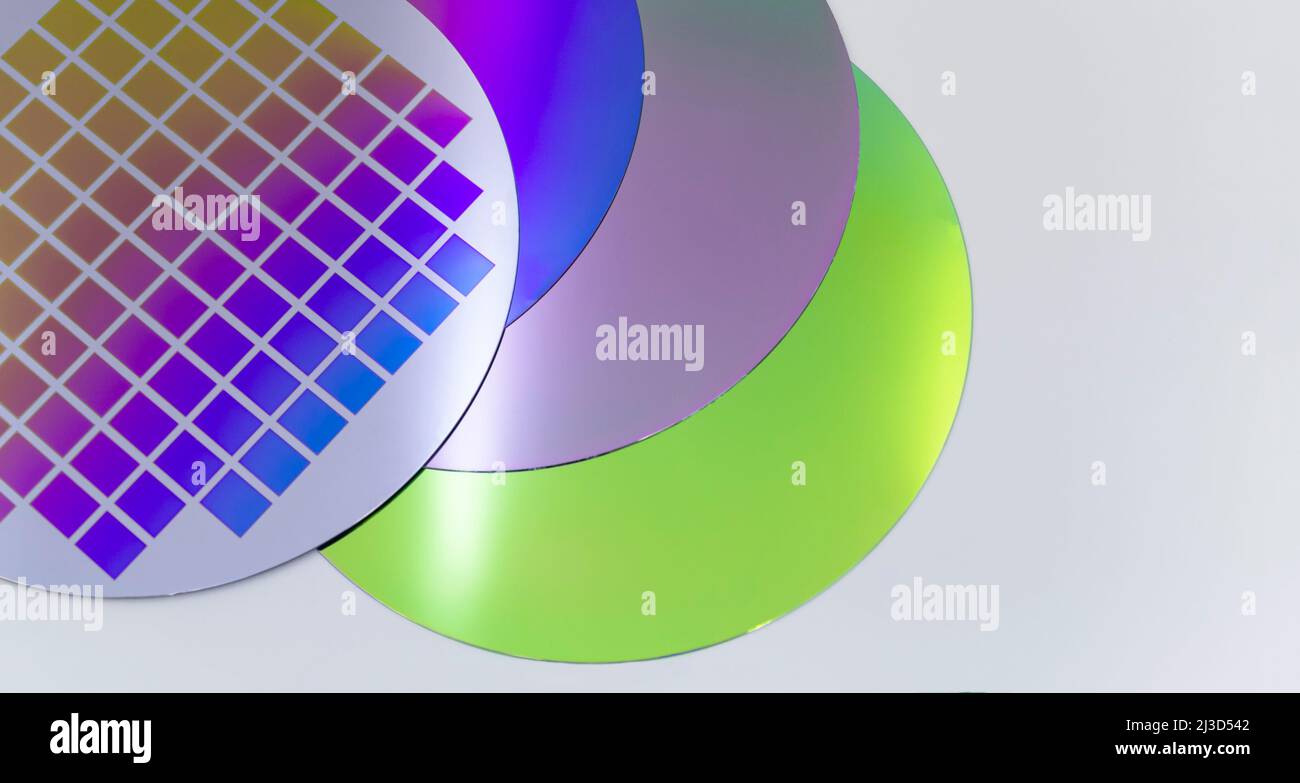 Mehrere Silizium-Wafer mit gedruckter Schaltung und unterschiedlicher Farbe. Bannerformat. Stockfoto