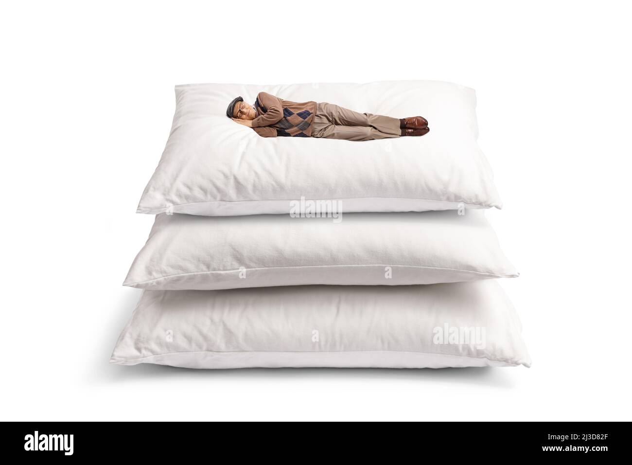 Edlerly Mann schläft auf einem Haufen von Kissen isoliert auf weißem Hintergrund Stockfoto