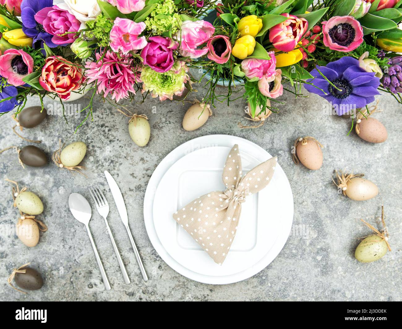 Ostertisch-Dekoration mit bunten Frühlingsblumen und Eiern Stockfoto