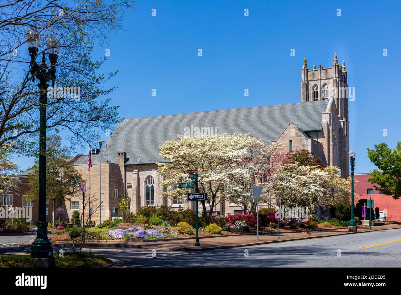 CONCORD, NC, USA-3 APRIL 2022: St. James Lutheran Church, mit Glockenturm, an der Ecke von Union und Corban., mit Frühlingsblumen und Bäumen in Stockfoto