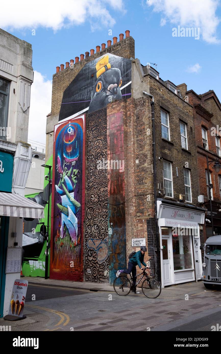 Radfahrer und bunte Wandgemälde an der Wand des Gebäudes in der Garrett St und Whitecross Street in 2022 London EC1 England Großbritannien Kathy DeWitt Stockfoto