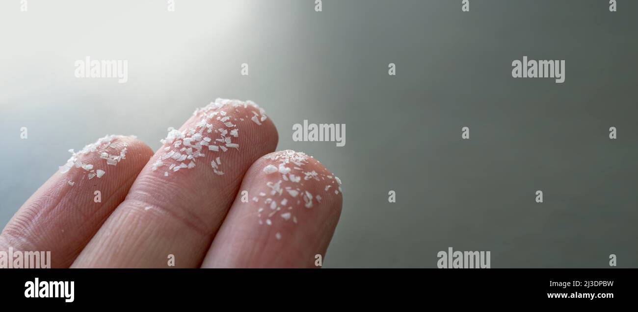 Nahaufnahme von Mikroplastik auf menschlichen Fingern. Konzept für Wasserverschmutzung und globale Erwärmung. Idee zum Klimawandel. Stockfoto