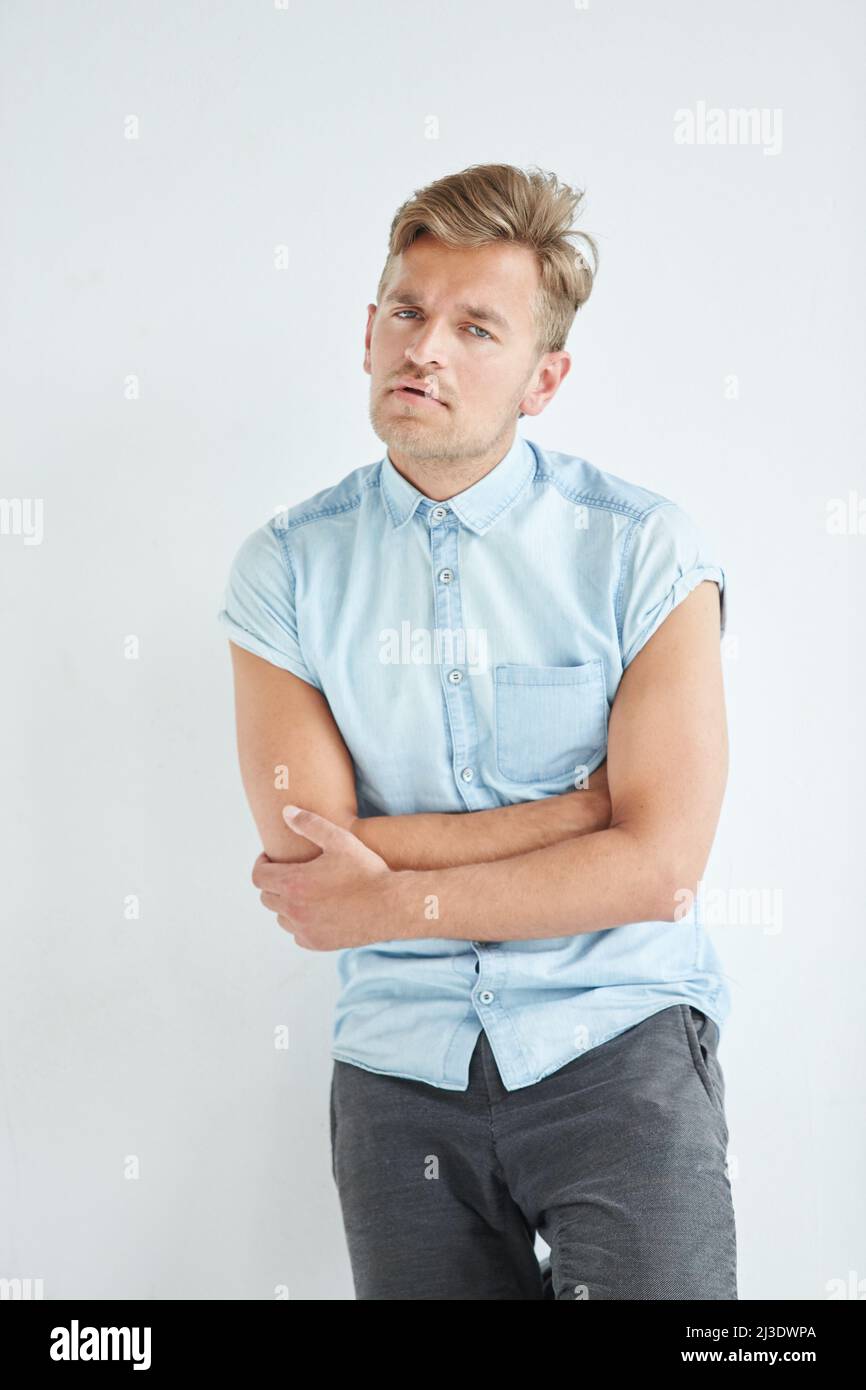 Brutaler Mann in einem Hemd mit kurzen Ärmeln, seine Fäuste geballt, leicht gebeugt, unter dem Blick der Stirn Stockfoto