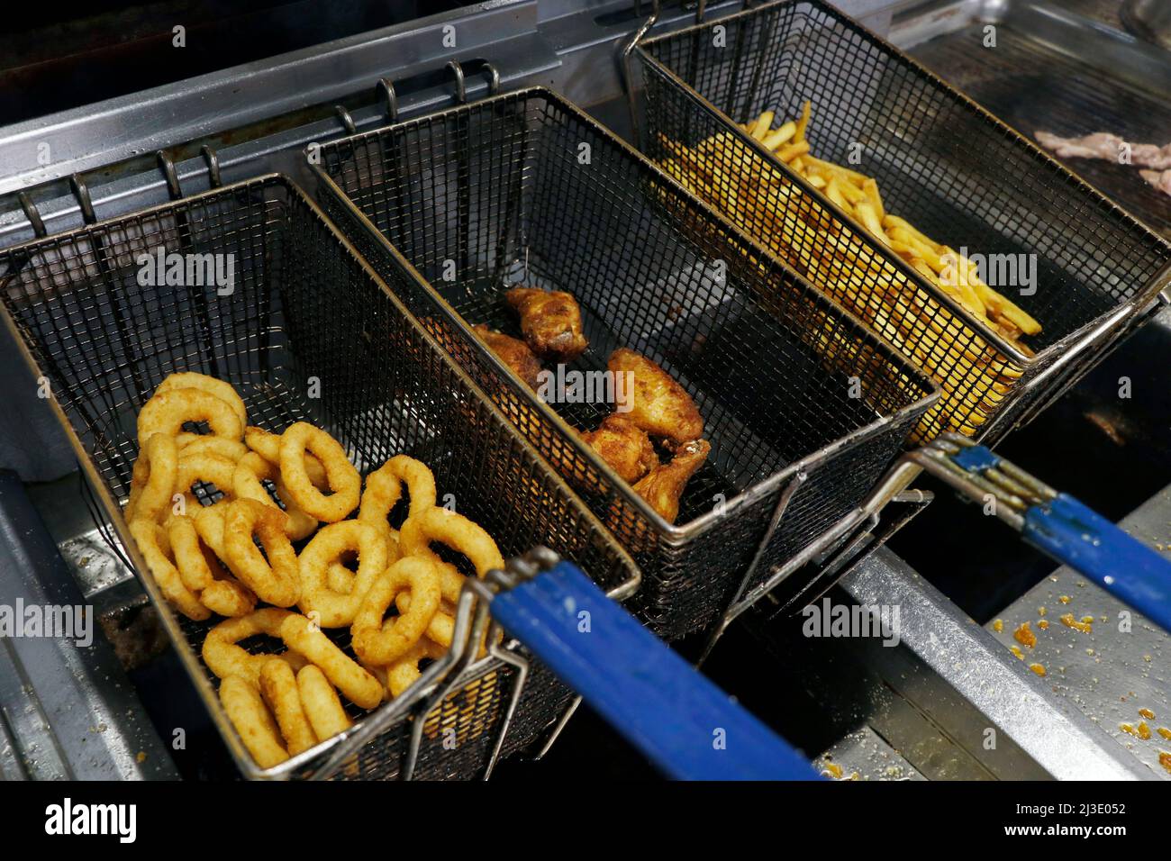 Frittierte Snacks Lebensmittel in einem fetten Frittierkorb, ungesunde und Junk-Food-Konzept Stockfoto