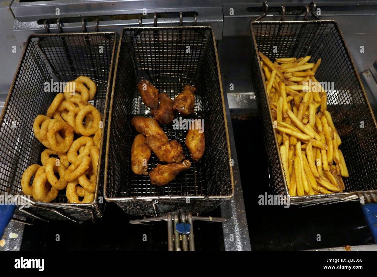 Frittierte Snacks Lebensmittel in einem fetten Frittierkorb, ungesunde und Junk-Food-Konzept Stockfoto