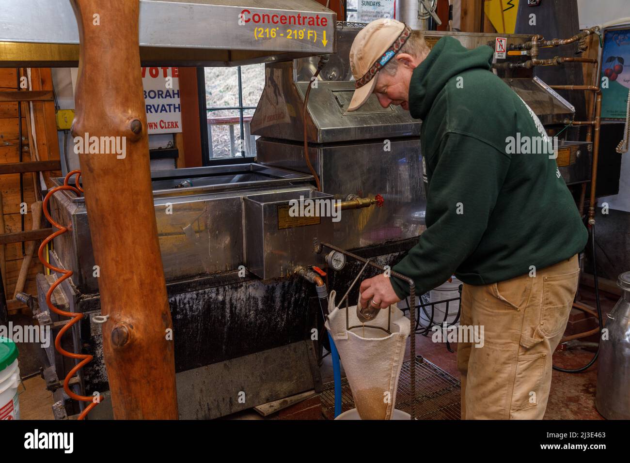 Ahornsirup herstellen: Der Mensch reinigt „Zuckersand“ aus seinem Verdampfer. Cherry Valley, Otsego County, Bundesstaat New York. Stockfoto