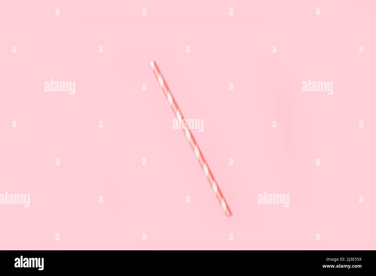 Weiß und rosa gestreifter Trinkhalm auf einem rosa Hintergrund mit Kopierfläche Stockfoto