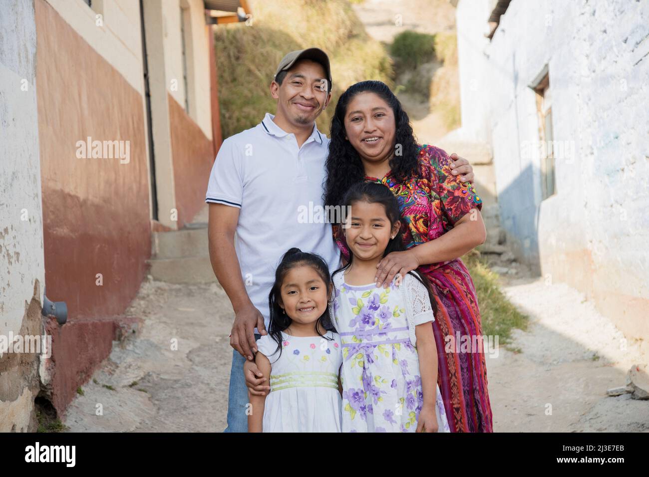 Hispanische Familie außerhalb ihres Hauses - guatemaltekische Familie in der Gasse ihrer Nachbarschaft Stockfoto