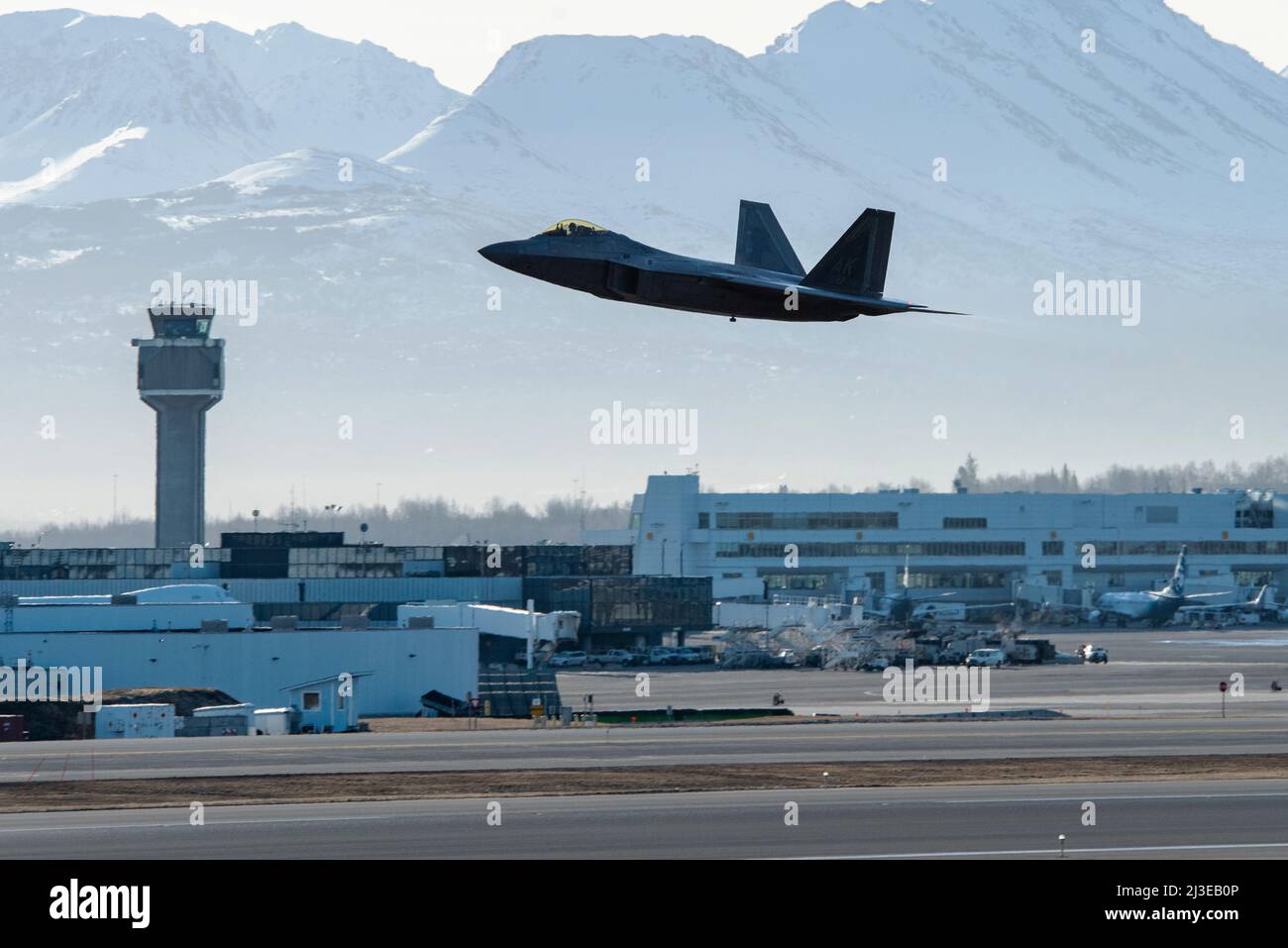 Ein dem 3. Wing zugewiesener US Air Force F-22 Raptor hebt während der Polar Force 22-4 in Anchorage, Alaska, am 7. April 2022 vom internationalen Flughafen Ted Stevens Anchorage ab. Der F-22 erhöht die Letalität gegen alle fortgeschrittenen Luftbedrohungen, indem er die Fähigkeiten der Gegner minimiert, den Jet aufgrund seiner Tarnung, integrierten Avionik und Supercruise-Eigenschaften zu verfolgen und mit ihm zu interagieren. Die Eigenschaften des F-22 bieten synergistische Effekte und erhöhen die Letalität gegen alle fortgeschrittenen Luftbedrohungen. (USA Luftwaffe Foto von Senior Airman Samuel Colvin) Stockfoto