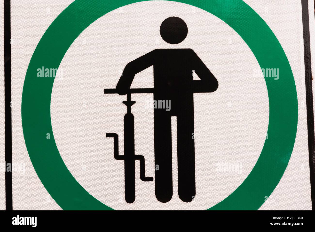 Schwarz, grün und weiß gehen neben Fahrrad-Piktogramm-Schild. Stockfoto