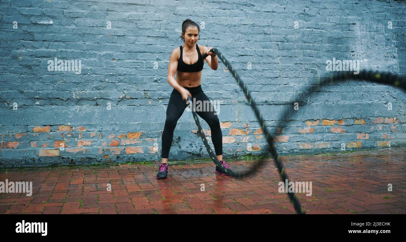 Du bist nur so gut, wie du denkst. Schoss eine athletische junge Frau, die Kampfseilwellen machte. Stockfoto