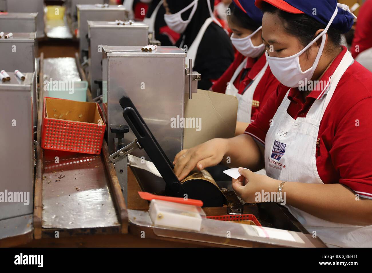 Eine Arbeiterin verpackt in Kediris Zigarettenfabrik „Gudang Garam“ Kretek-Zigaretten. KEDIRI, INDONESIEN – 27. Juni 2019: Stockfoto