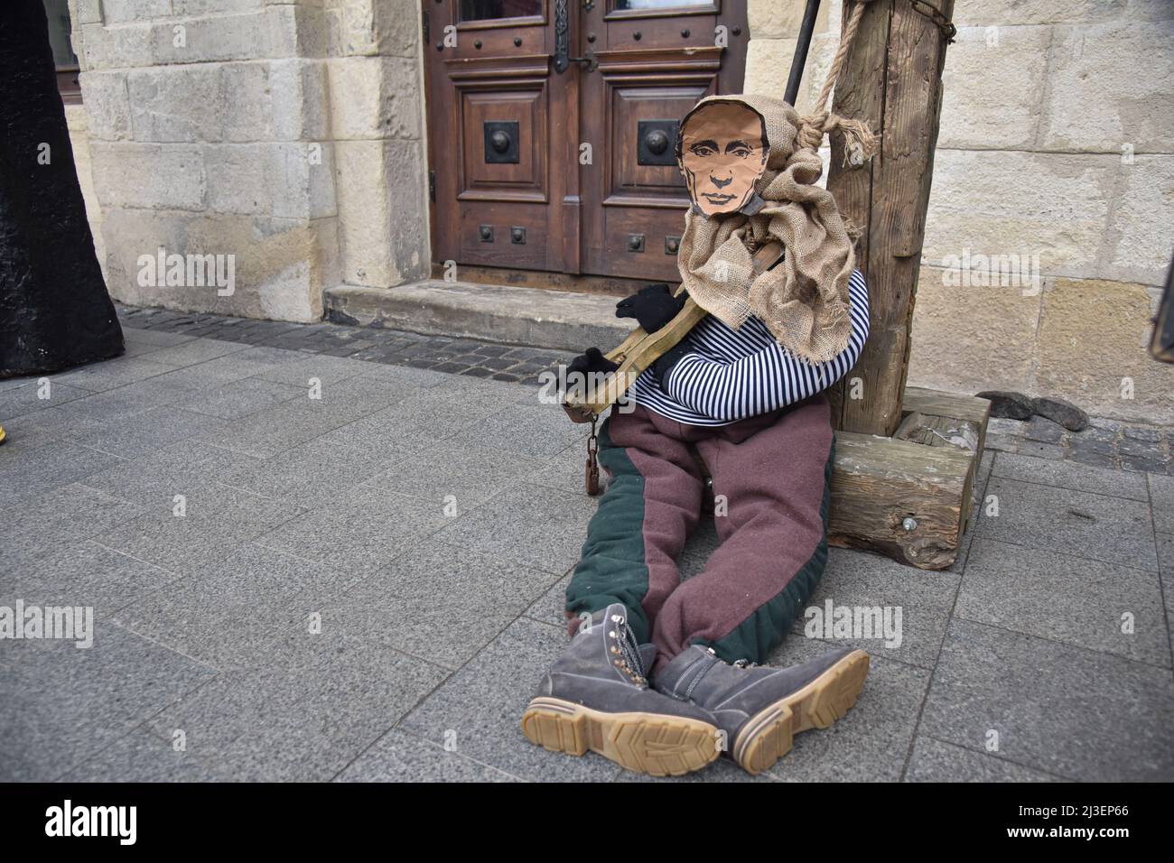 Lviv, Ukraine. 03. April 2022. Eine Schaufensterpuppe eines mittelalterlichen Gefangenen mit einem Porträt des russischen Präsidenten Wladimir Putin am Eingang des Cafés in Lemberg. Aufgrund der militärischen Invasion Russlands in die Ukraine wurde eine Schaufensterpuppe eines mittelalterlichen Gefangenen mit dem Kopf der Besatzungsmacht, Präsident Wladimir Putin, in mittelalterliche Folter versetzt - "die Geige des Sünders" - in der Nähe des Cafés von Lviv platziert.Quelle: SOPA Images Limited/Alamy Live News Stockfoto