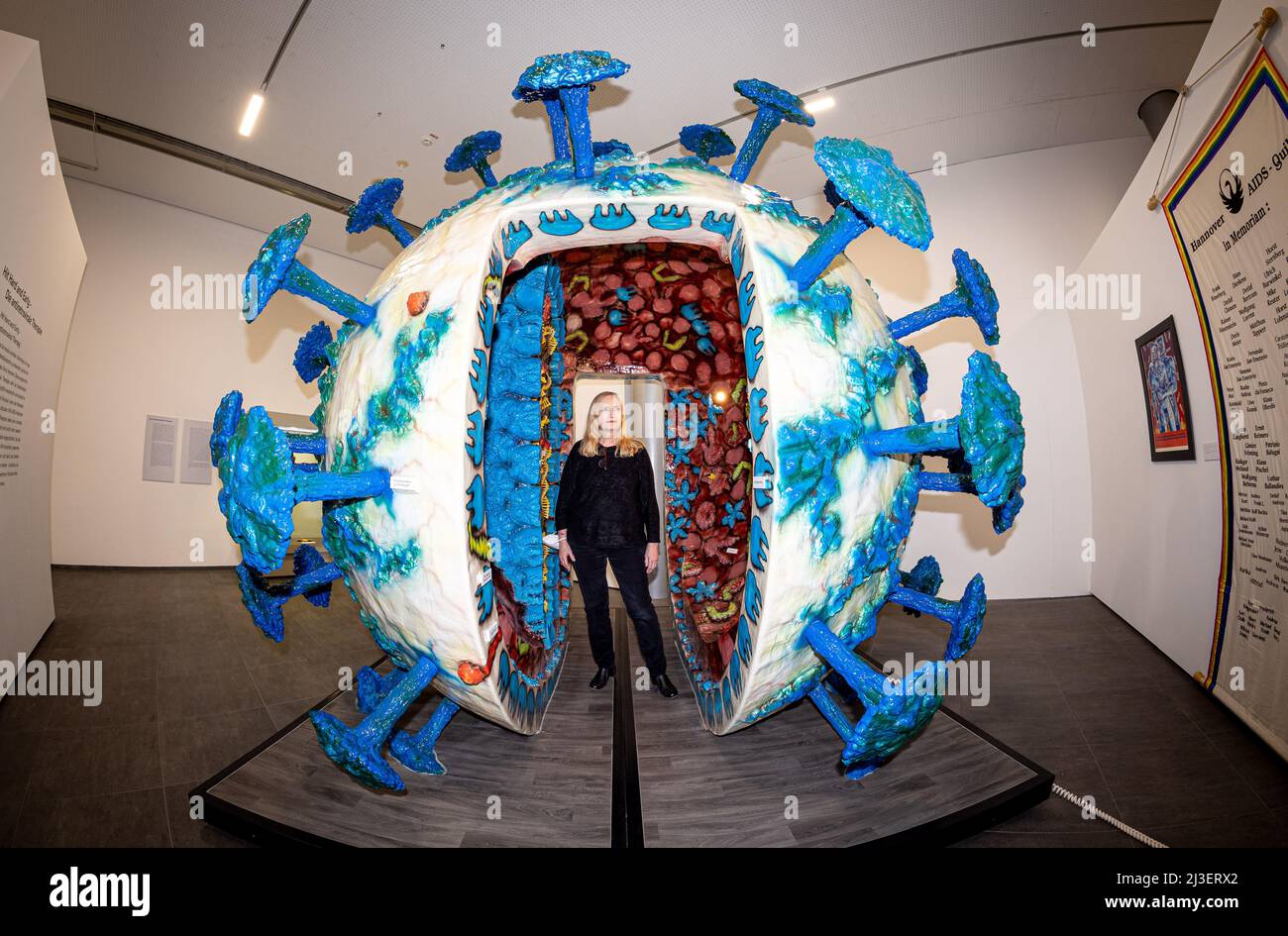 Hildesheim, Deutschland. 01. April 2022. Regine Schulz, Direktorin des Römer- und Pelizaeus-Museums Hildesheim (RPM), steht in der Sonderausstellung „Epidemien. Fluch der Vergangenheit - Bedrohung der Zukunft“ in einem begehbaren Modell des AIDS-Virus (HIV). (Foto mit Fischaugenobjektiv) die Schau, die von der Antike bis zur Gegenwart reicht, wird bis Mitte Juli verlängert. Quelle: Moritz Frankenberg/dpa/Alamy Live News Stockfoto