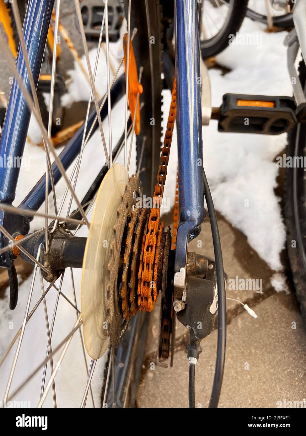 Blue Bike ist den ganzen Winter draußen gewesen und ist kaputt gegangen.  Rostige Fahrradkette hängt an Kettenrad und Zahnrad Stockfotografie - Alamy