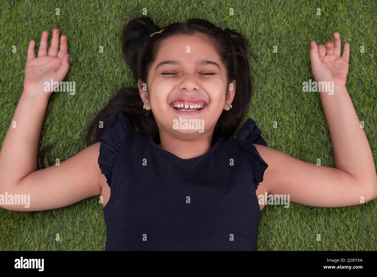 Blick von oben auf das Mädchen, das auf dem Gras liegt Stockfoto