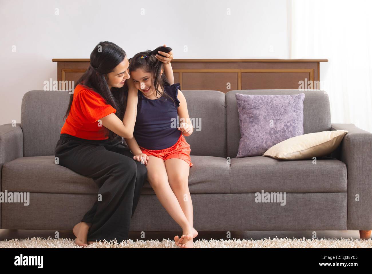 Mutter hat Spaß mit ihrer Tochter, indem sie an den Haaren zieht Stockfoto