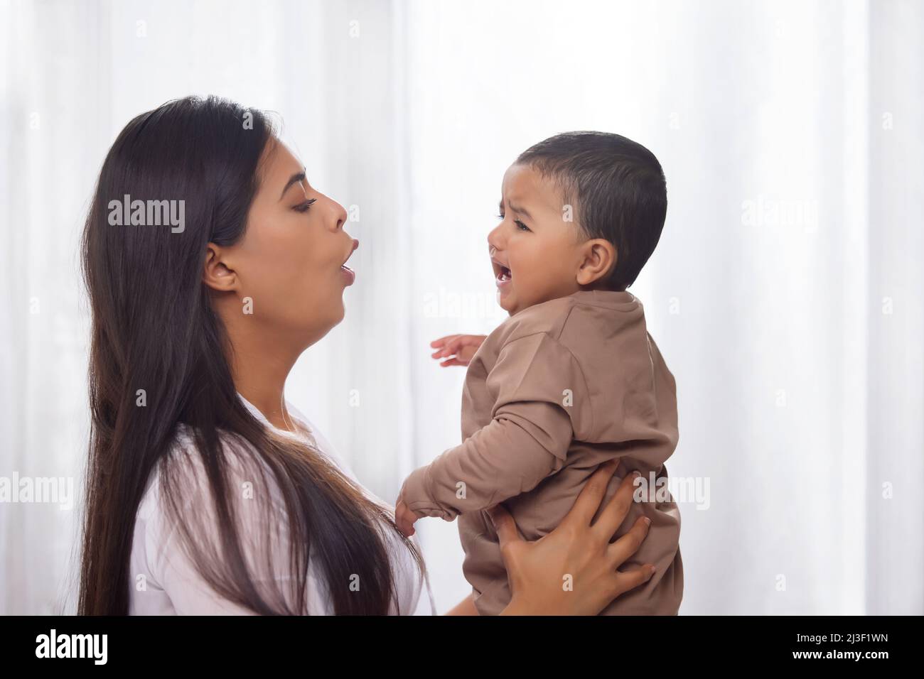 Porträt einer Mutter, die ihr weinendes Baby beruhigt Stockfoto