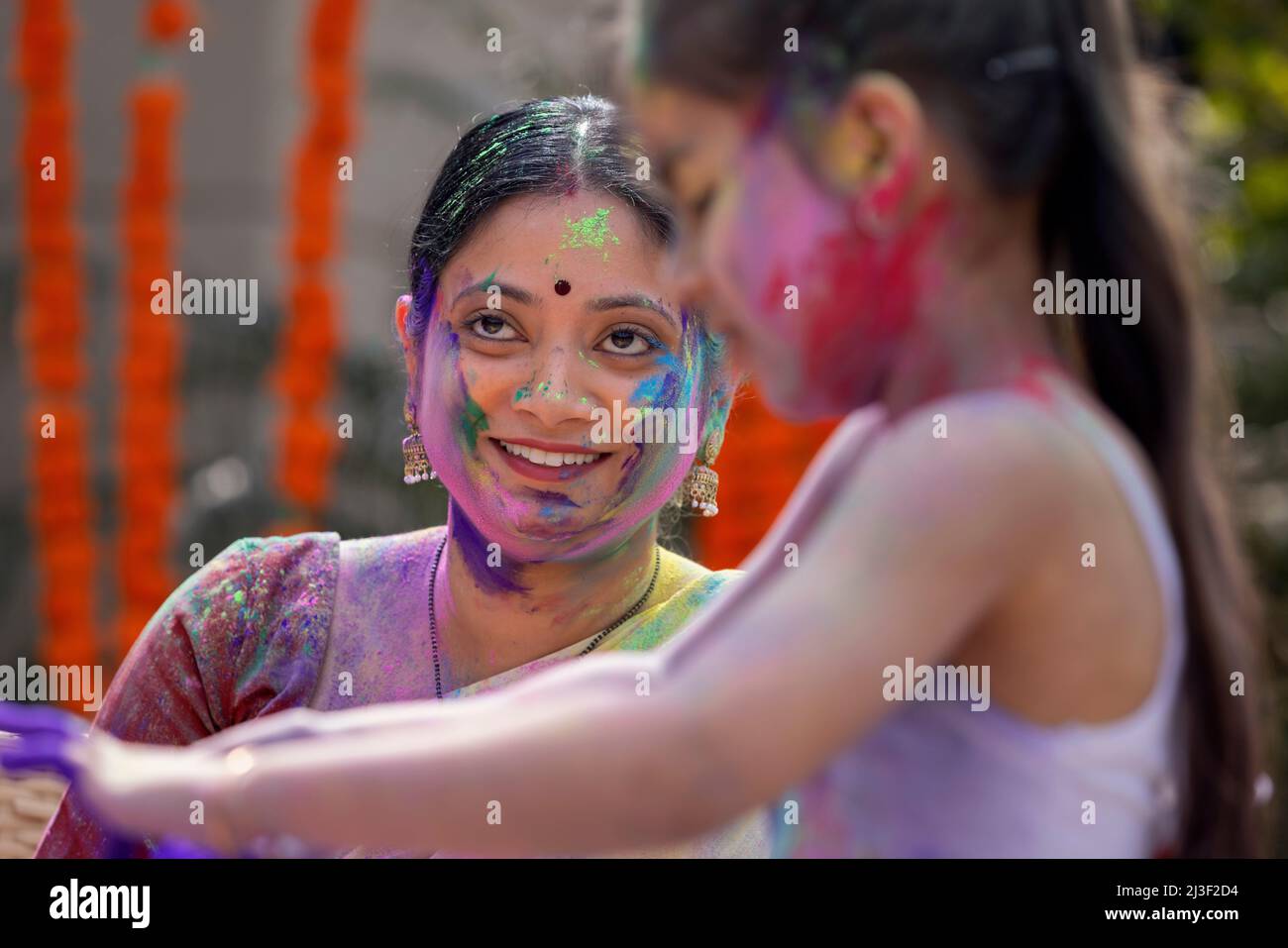 Porträt einer aktiven älteren Frau mit farbenfrohem Gesicht, das Holi feiert Stockfoto
