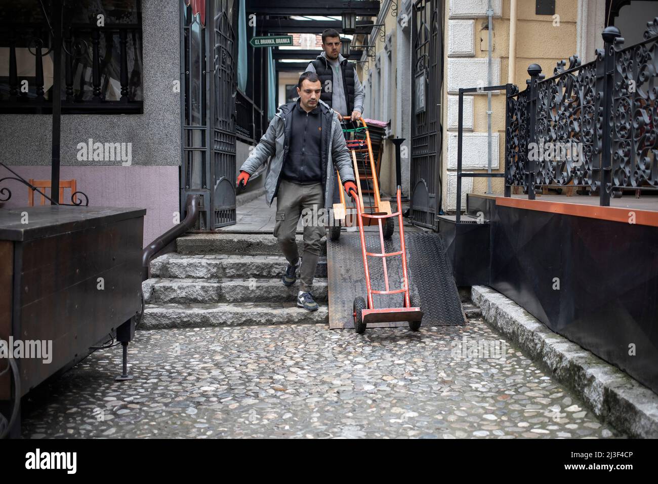 Belgrad, Serbien, 7. April 2022: Arbeiter schieben nach der Lieferung einen leeren, aufrechten Wagen Stockfoto