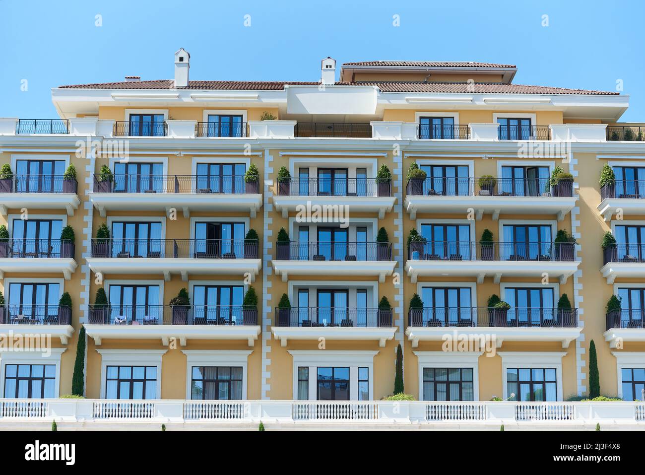 Fassade eines luxuriösen Apartmentgebäudes mit Balkonen und Topfpflanzen Stockfoto