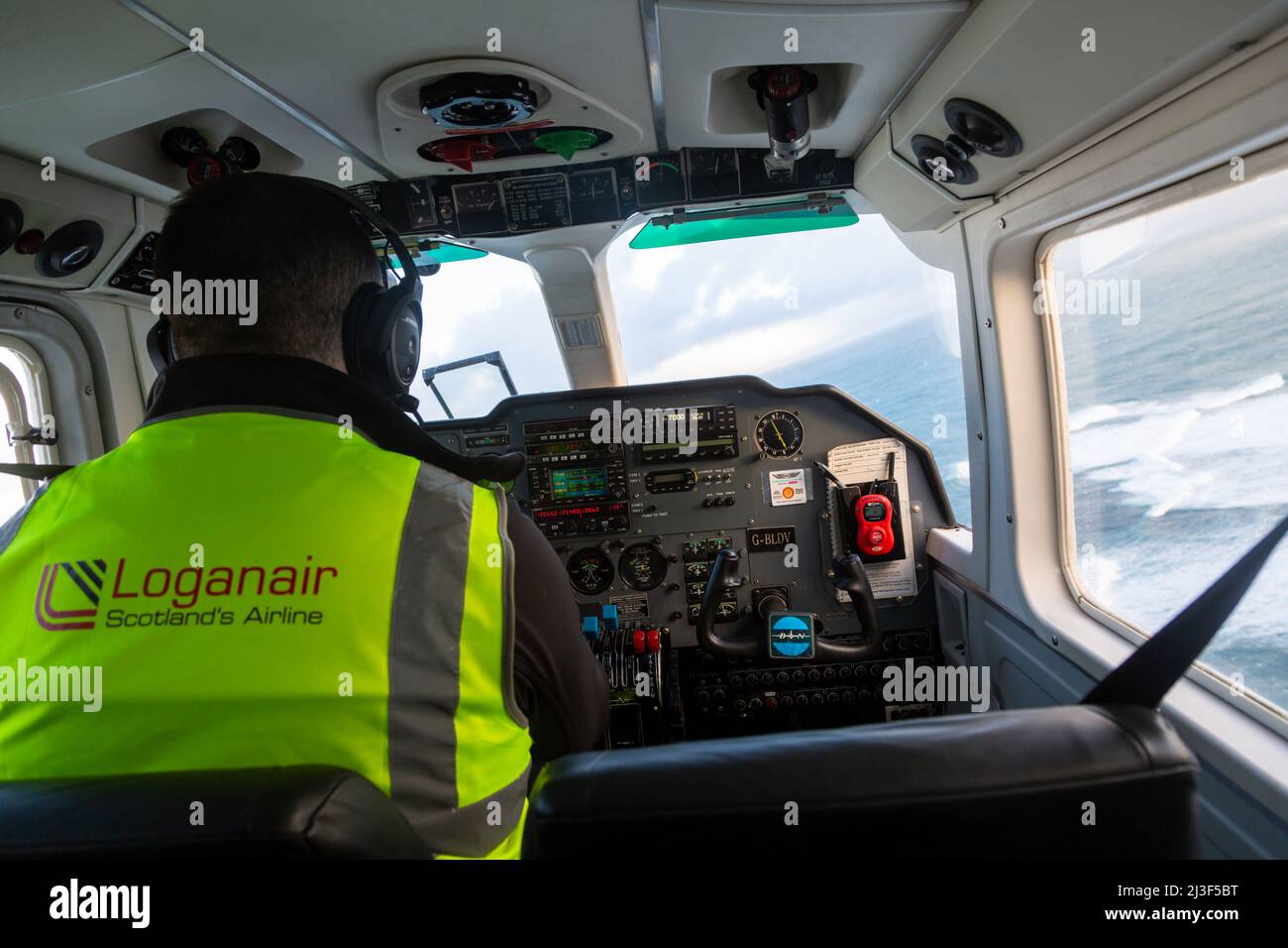 Pilot in der Luft, Loganair Kleinflugzeug auf dem Weg nach Papa Westray, Orkney Islands, Großbritannien Stockfoto