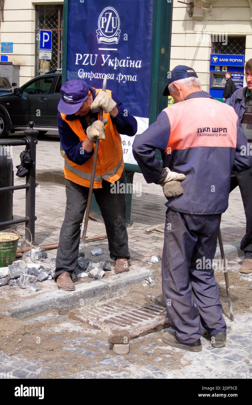 Arbeiter reparieren gepflasterte Straßen, Stadtzentrum, Lemberg, Ukraine Stockfoto