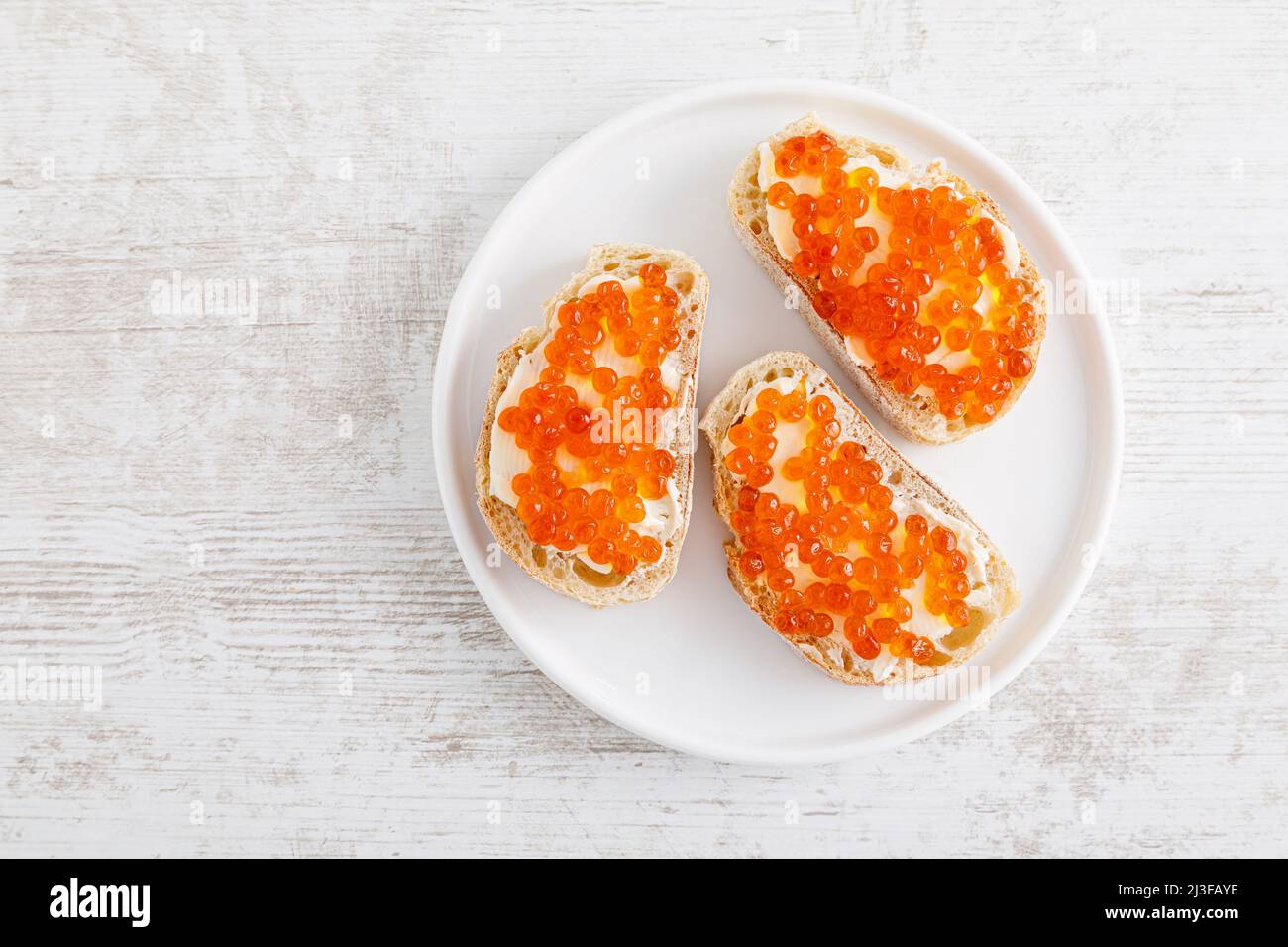 Offene Sandwiches mit Kaviar aus rotem Lachs. Draufsicht, flach liegend Stockfoto