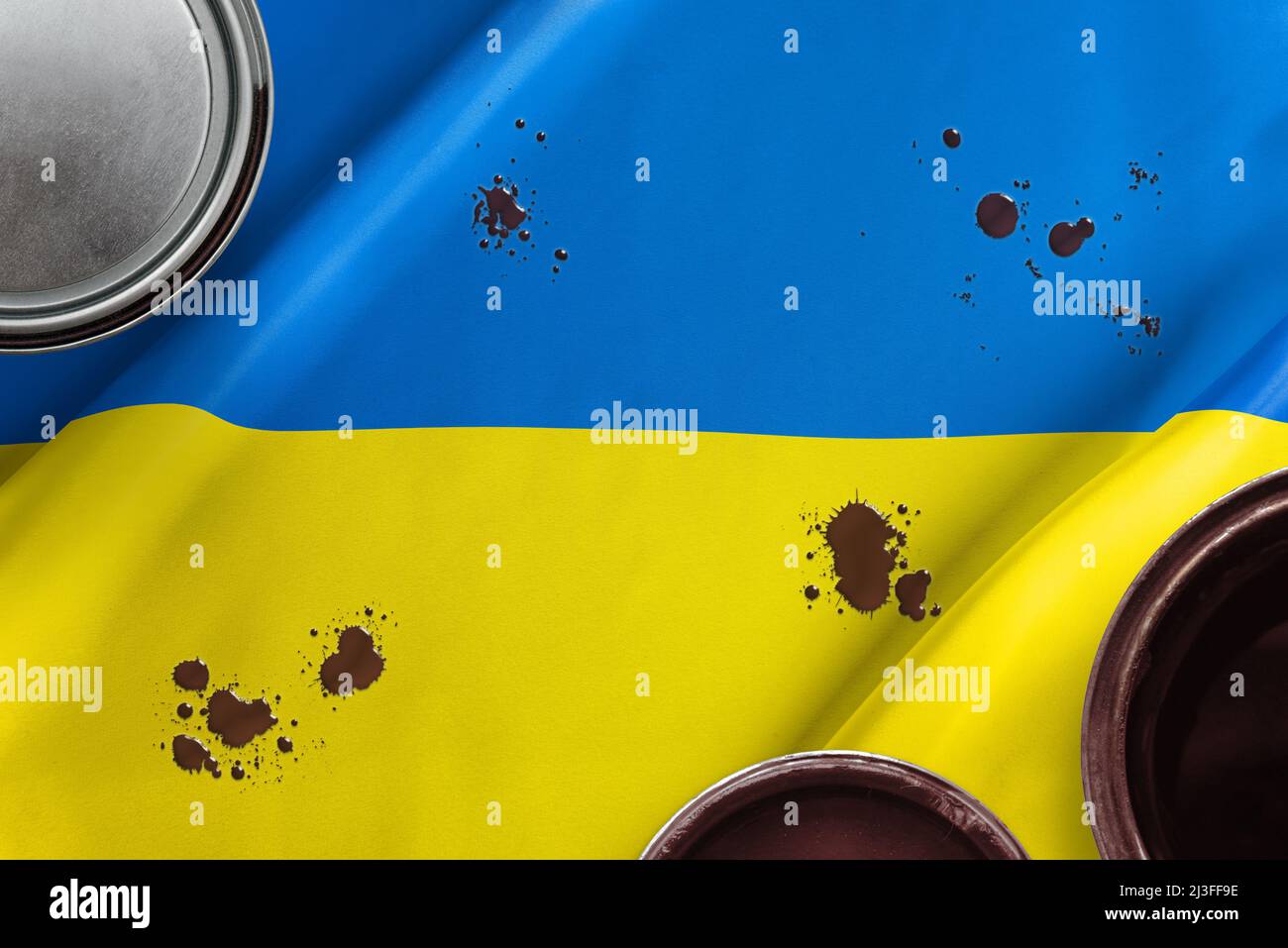 Öl auf der ukrainischen Flagge. Das Konzept des Ölflusses und der Ölversorgung in Zeiten von Krieg und Wirtschaftskrise Stockfoto