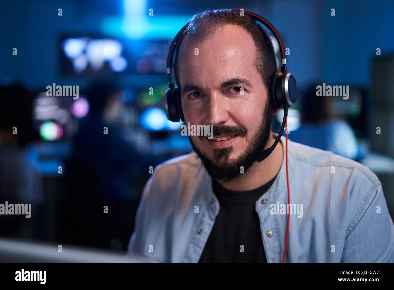 Porträt lächelnd Blick auf die Kamera eines glücklichen Aktienmarkt-Trader Working Investment Charts, Grafiken. Finanzanalyst und Digital Business man in einem Stockfoto