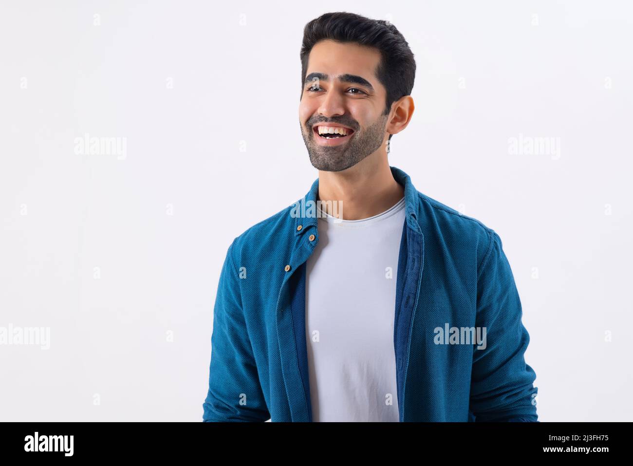 Porträt eines glücklichen jungen Mannes, der woanders hinschaut und lacht Stockfoto